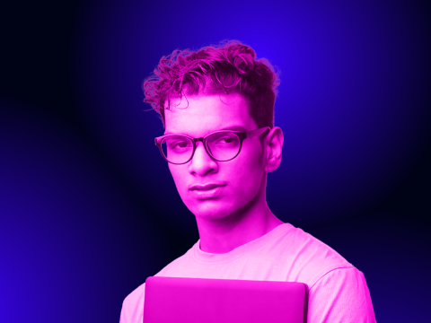 Young man with glasses holding a laptop